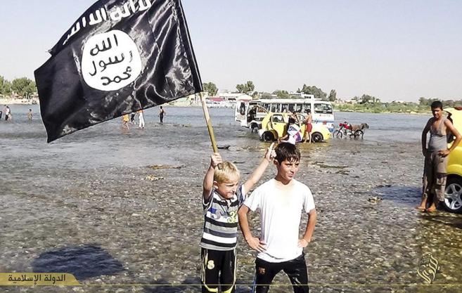 Nios con una bandera del IS en Mosul, en una imagen difundida en...
