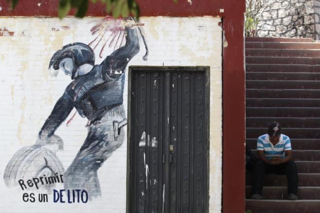 Un hombre espera en las escaleras de la escuela de Ayotzinapa, donde...