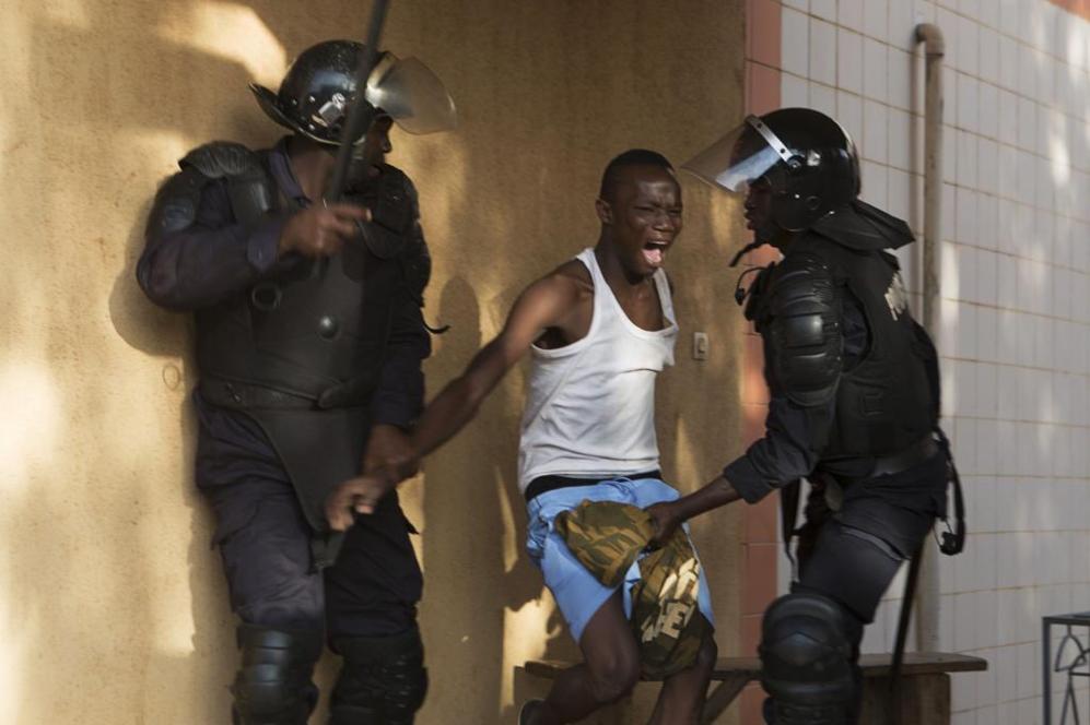 Dos policas detienen a un manifestante en la capital de Burkina...