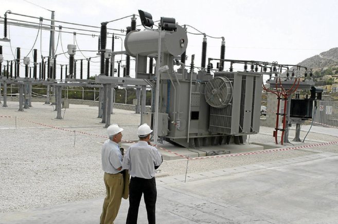 Dos tcnicos observan  el funcionamiento de una central elctrica en...