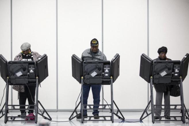 Tres electores ejercen su derecho a voto en Ferguson, Missouri.