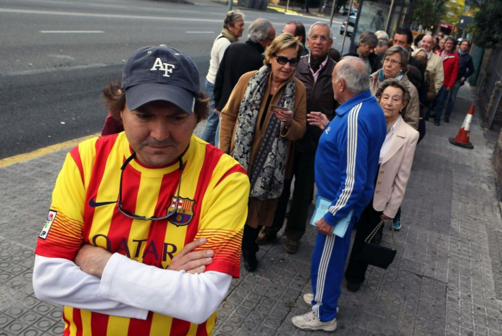 Colas de ciudadanos esperan en la Va Augusta de Barcelona la...