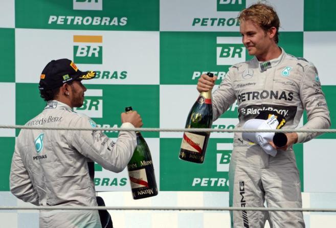 Lewis Hamilton (izda) brinda con Nico Rosberg, sobre el podio de...