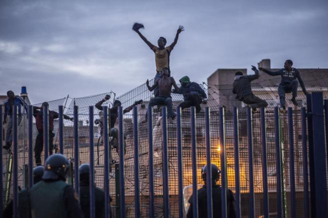 Inmigrantes encaramados en la valla de Melilla el pasado marzo.
