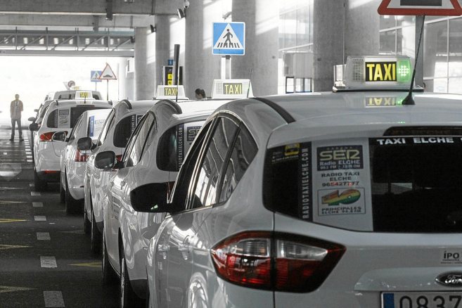 Taxis de Elche aparcados en la terminal de llegadas del aeropuerto...
