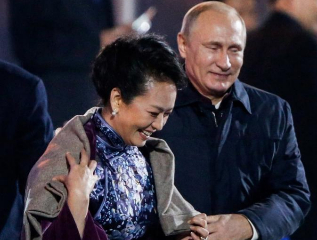 Putin pone su chaqueta sobre Peng Liyuan.