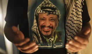 Un palestino con una camiseta de Arafat reza en su tumba. EFE