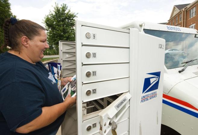 Una empleada del servicio postal estadounidense repartiendo la...