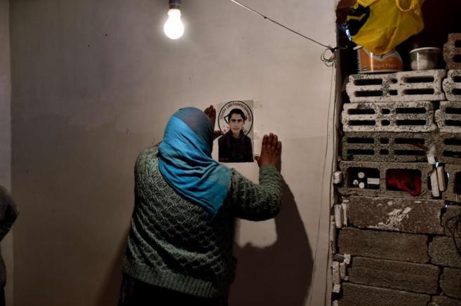 Una ciudadana siria prende una foto de su hijo a la pared, que muri...