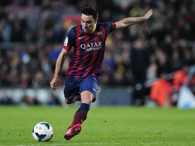 Xavi, a punto de dar un pase, en un partido con el Barcelona.
