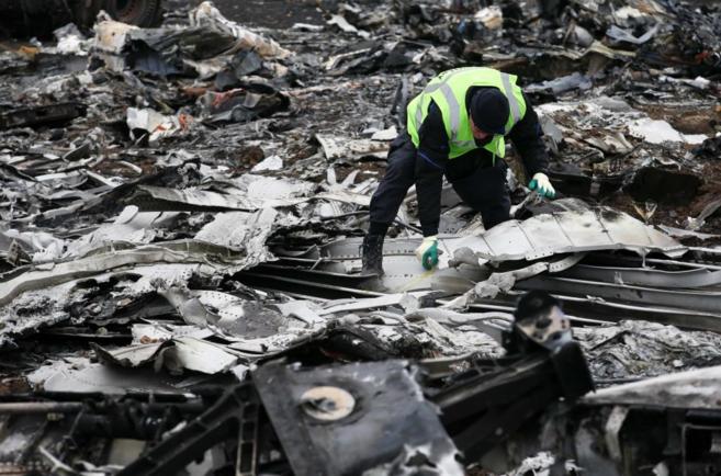 Un investigador holands examina los restos del MH17 de Malaysia...