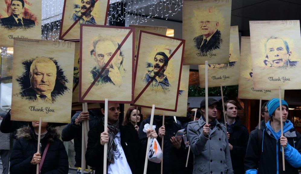 Unos manifestantes sostienen retratos del ex presidente cubano Fidel...