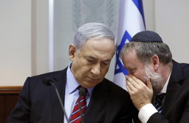 El primer ministro Netanyahu (izda.) escucha a su jefe de Gabinete, en...