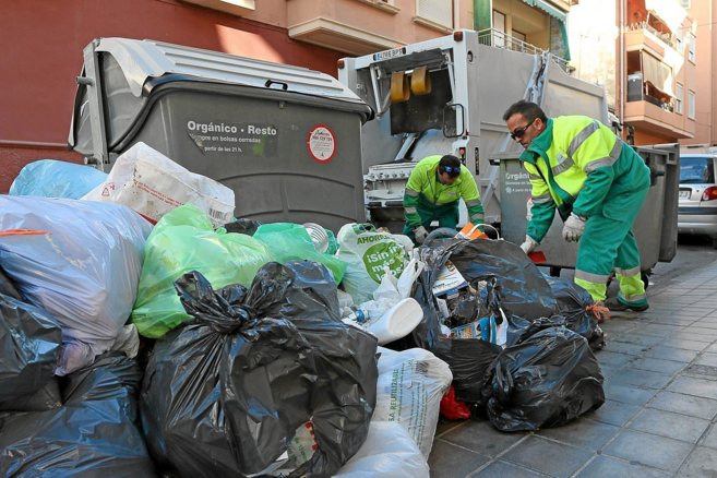 Dos trabajadores de la UTE Alicante retiran basuras tras la huelga...