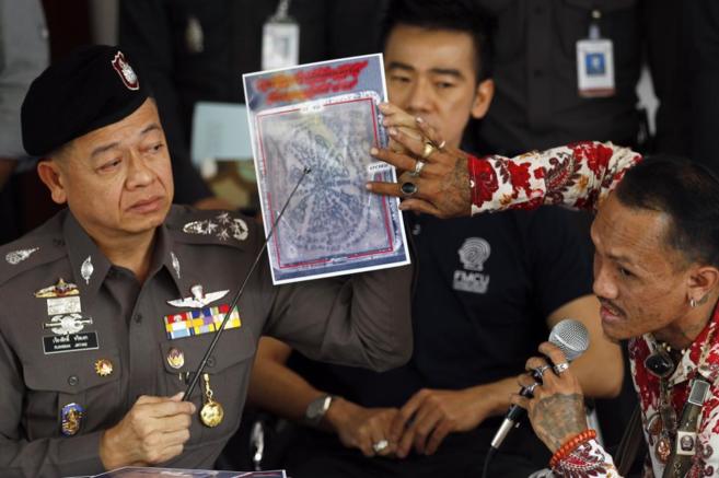 La polica tailandesa informa, junto a un experto en tatuajes...