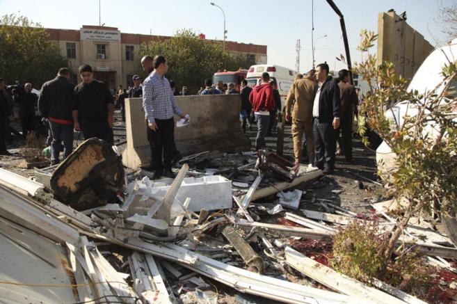 Las fuerzas de seguridad iraquíes inspeccionan el lugar del atentado...