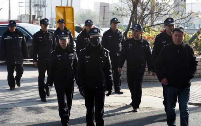 Agentes chinos patrullan las calles cercanas al tribunal donde se...