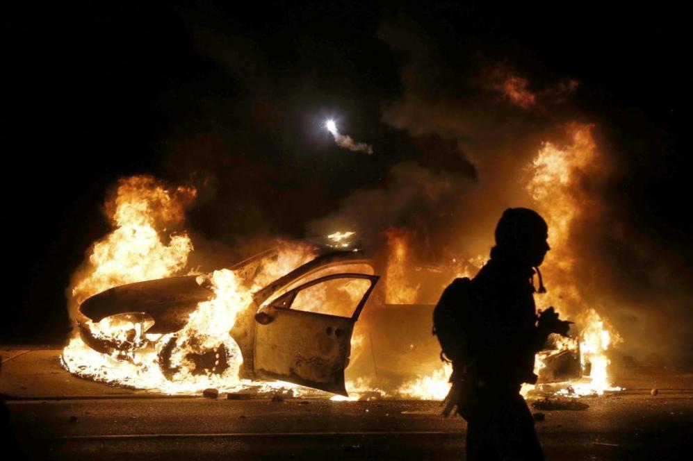 Un coche de polica arde durante los disturbios en Ferguson.