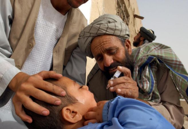 Un trabajador pone una vacuna contra la polio a un nio en Kandahar....