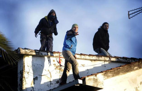 El bombero (centro) y otros dos activistas en el tejado de la...