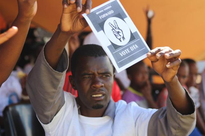 Un ciudadano namibio muestra un panfleto de apoyo al partido de la...