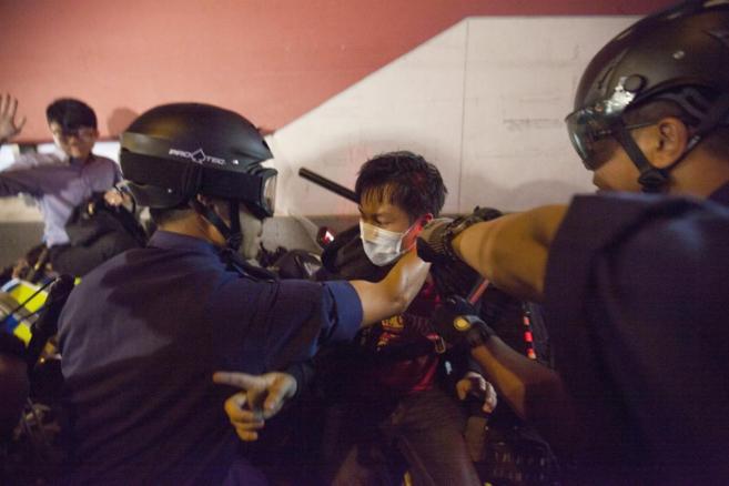 Dos policas detienen a un manifestante en el barrio de Mong Kok.