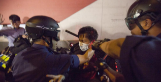 Dos policas detienen a un manifestante.