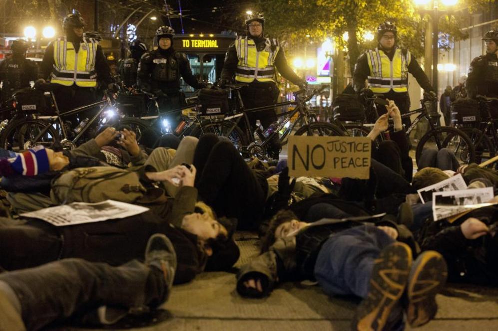 Manifestantes simulan estar muertos durante una protesta en Seattle