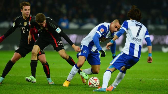 Müller y Götze pelean un balón ante dos jugadores del Hertha.