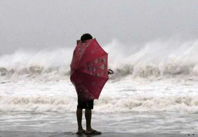 Una mujer residente en Borongan observa el mar ya bajo  los efectos...