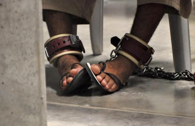 Los pies de un preso esposado durante una clase en la prisin de...
