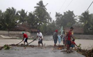 Filipinos achican agua en una zona inundada.