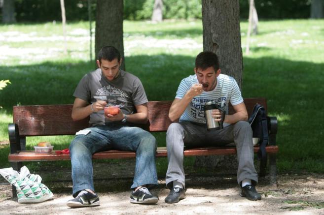Gente comiendo en un parque.