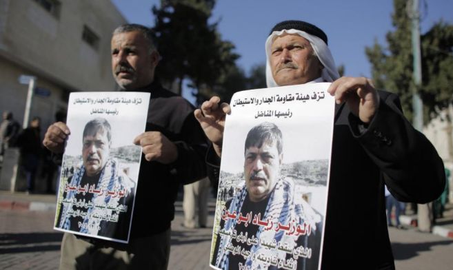 Dos palestinos sujetan carteles del ministro fallecido.