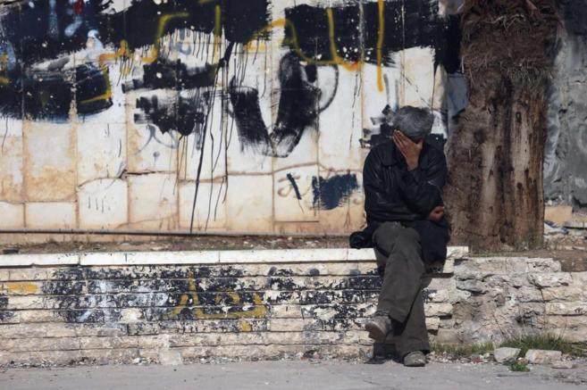 Un hombre, junto a un grafiti en el que se lee 'Al es...