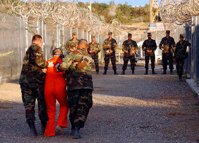 Soldados estadounidenses trasladan a un preso en la base de...