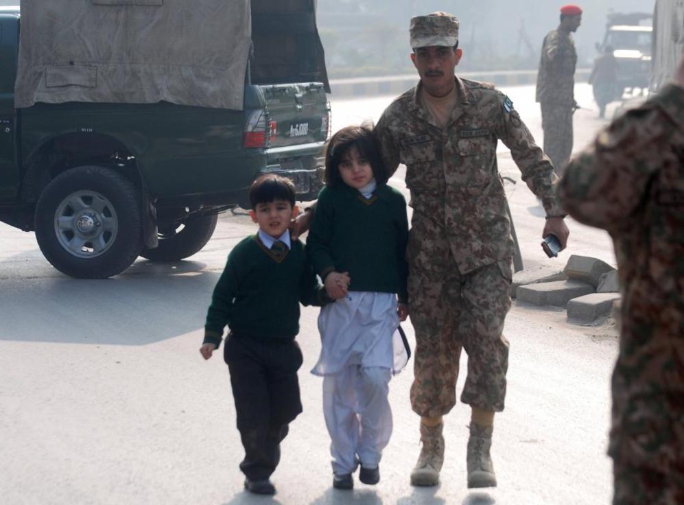 Un soldado escolta a dos nios tras ser rescatados de la escuela...