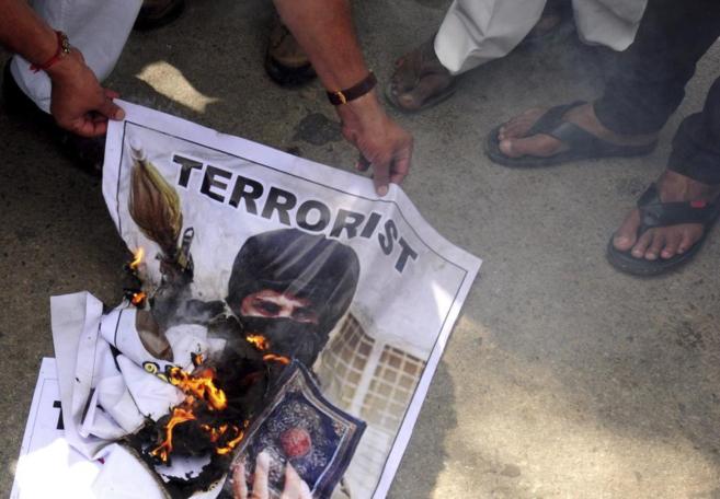 Manifestantes queman la fotografa de un terrorista en una protesta...