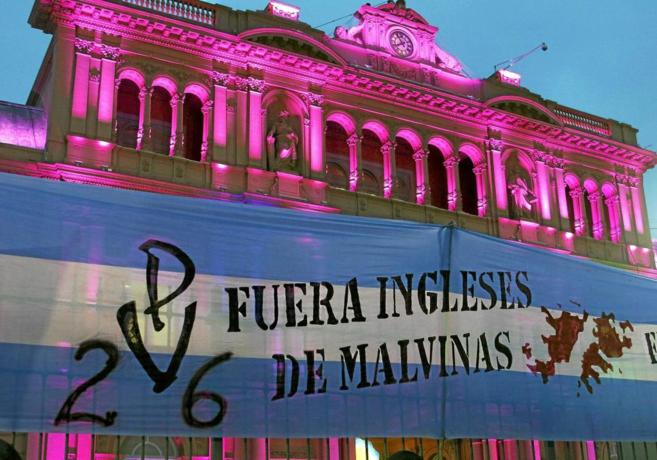Un cartel erigido frente a la Casa Rosada de Buenos Aires reza...