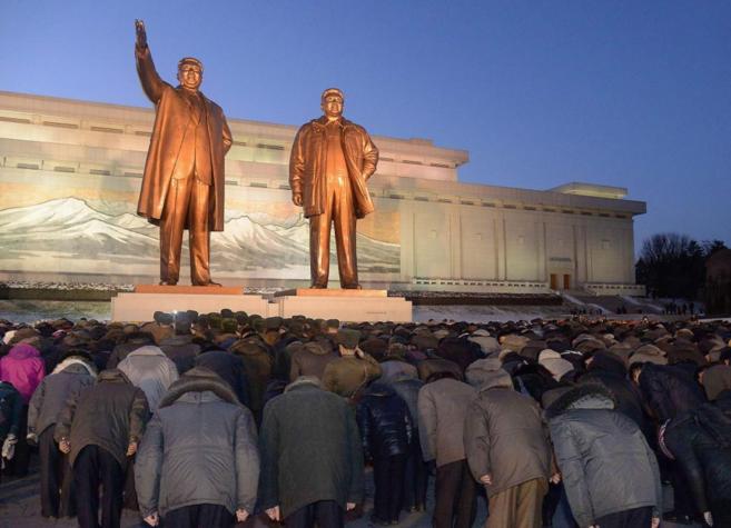 Norcoreanos se inclinan ante las estatuas de bronce del fundador Kim...