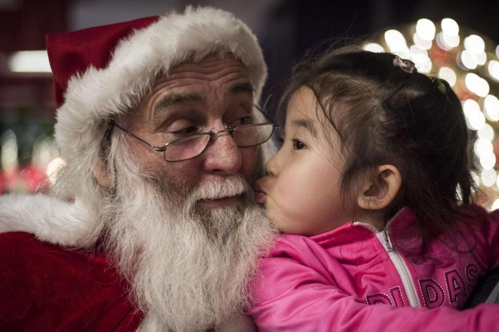 Una nia china besa a Santa Claus en el hotel Intercontinental de...