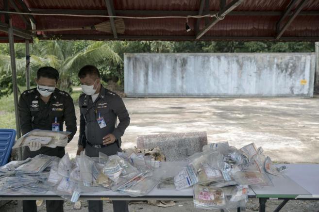 Policas tailandeses revisan las bolsas con objetos que se hallaban...