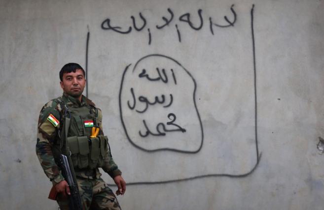 Un soldado peshmerga, frente a un grafiti del Estado Islmico en...
