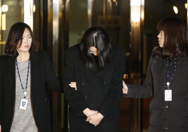 Cho Hyun-ah custodiada por dos agentes tras su detencin en Sel.