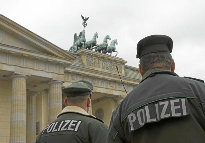 Dos agentes de policía alemanes observan la Puerta de Brandenburgo en...