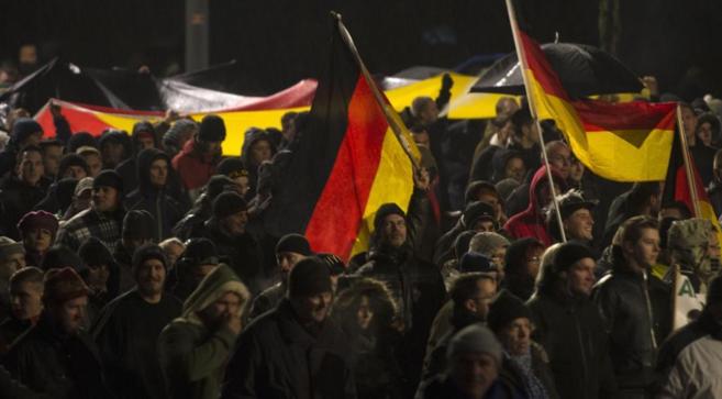 Manifestantes a favor de Pegida ondean banderas alemanas en la...
