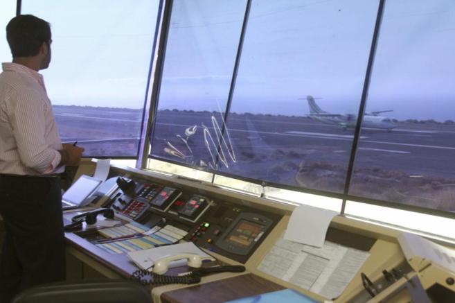 Un operario observa el aterrizaje de un avin desde la torre de...