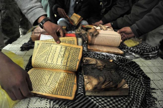 Un grupo de afganos muestra copias del Corn quemadas