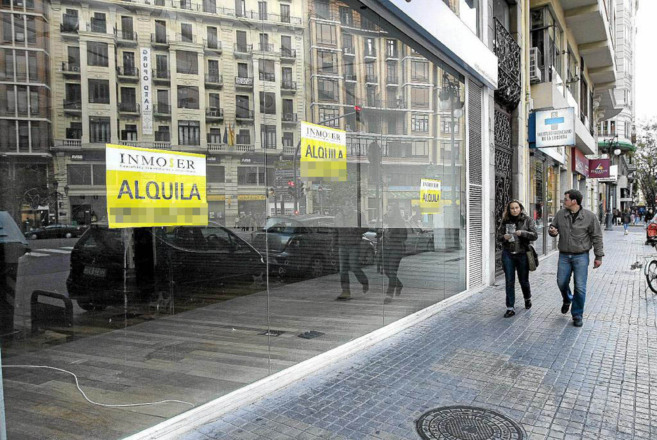 Carteles que anuncian el alquiler de locales comerciales en Valencia.