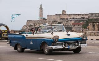 Dos turistas pasean en taxi por La Habana.